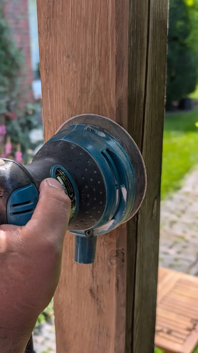 Holzpfosten wird mit einer Schleifmaschine für die weitere Pflege vorbereitet